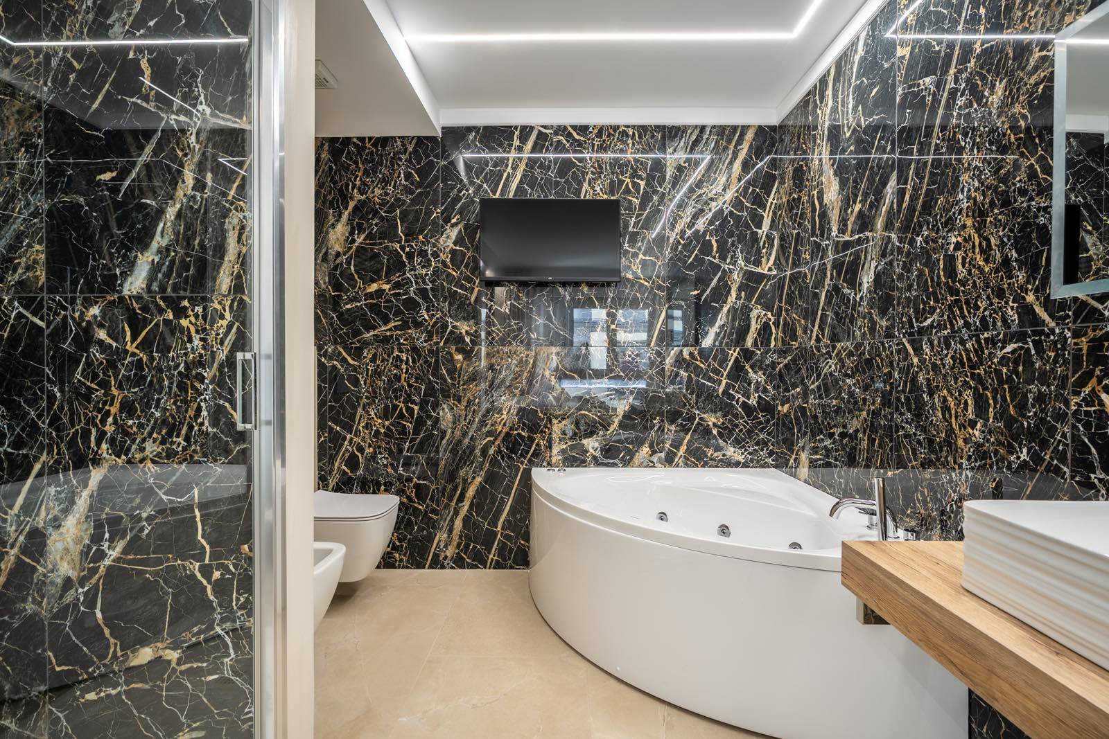 Bagno in marmo nero e oro con vasca idromassaggio, Il Magnifico Wellness Suite, Firenze
