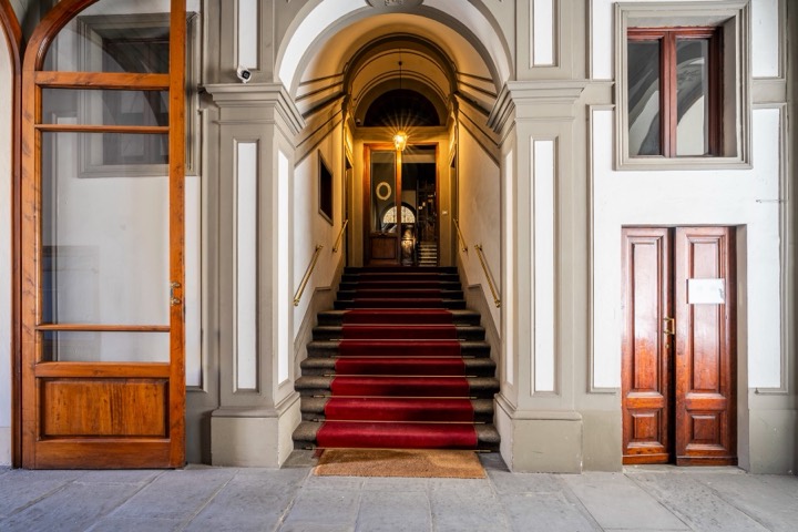 Scalone d'epoca con tappeto rosso in un palazzo storico, Firenze